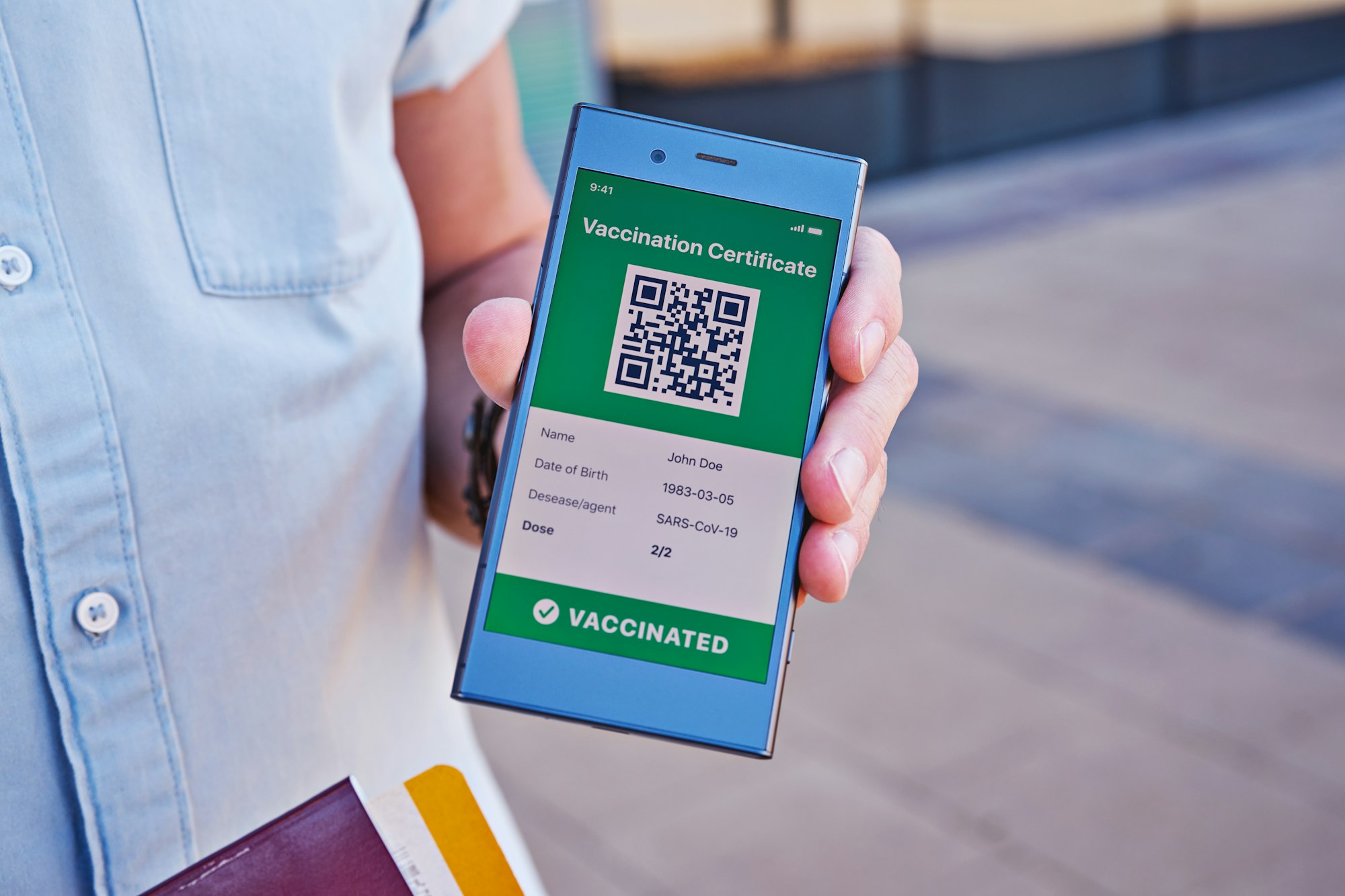 Hand with smartphone displaying on app mobile valid digital vaccination certificate for